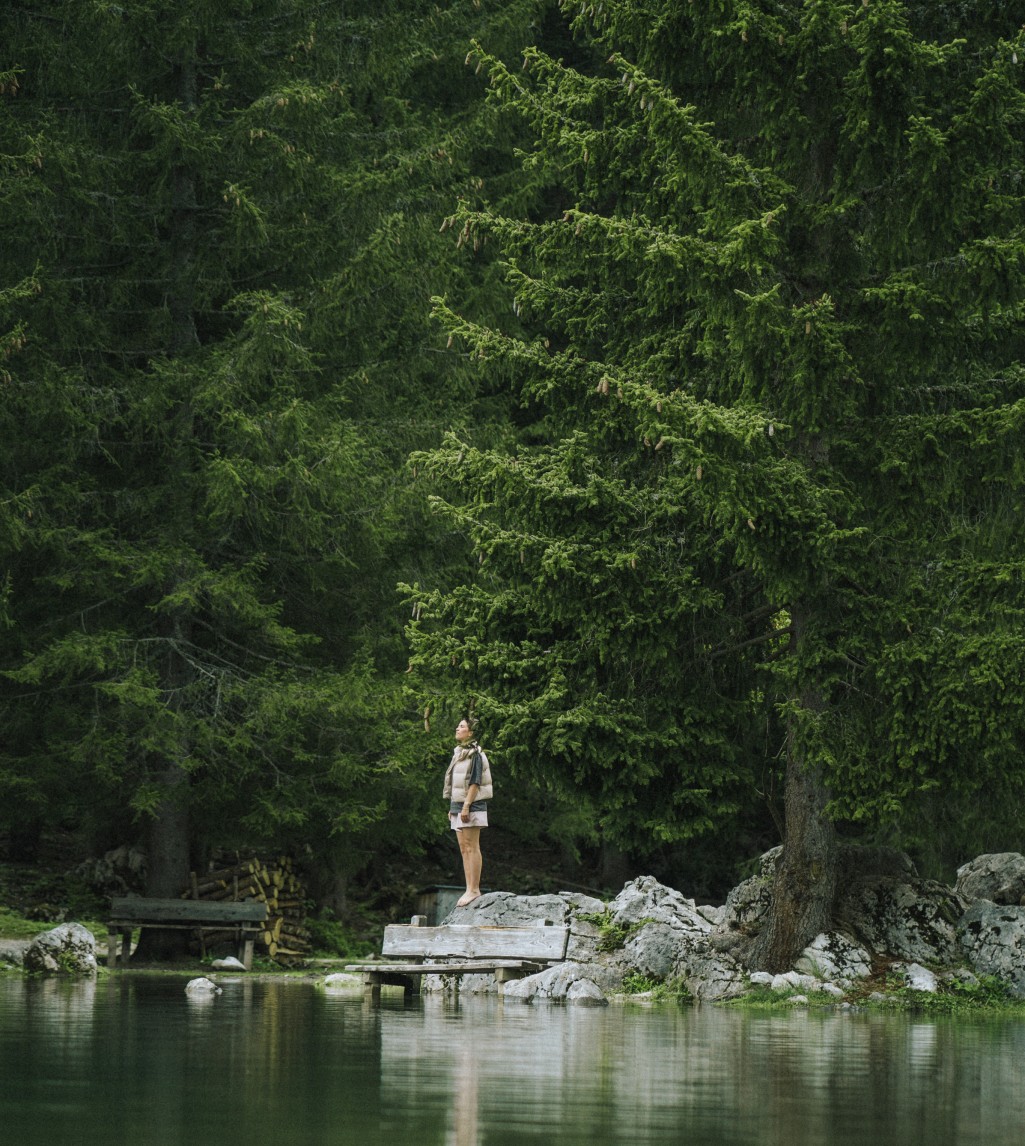 Eine Dame genießt die frische Luft in den Bergen mit einem traumhaften Ausblick