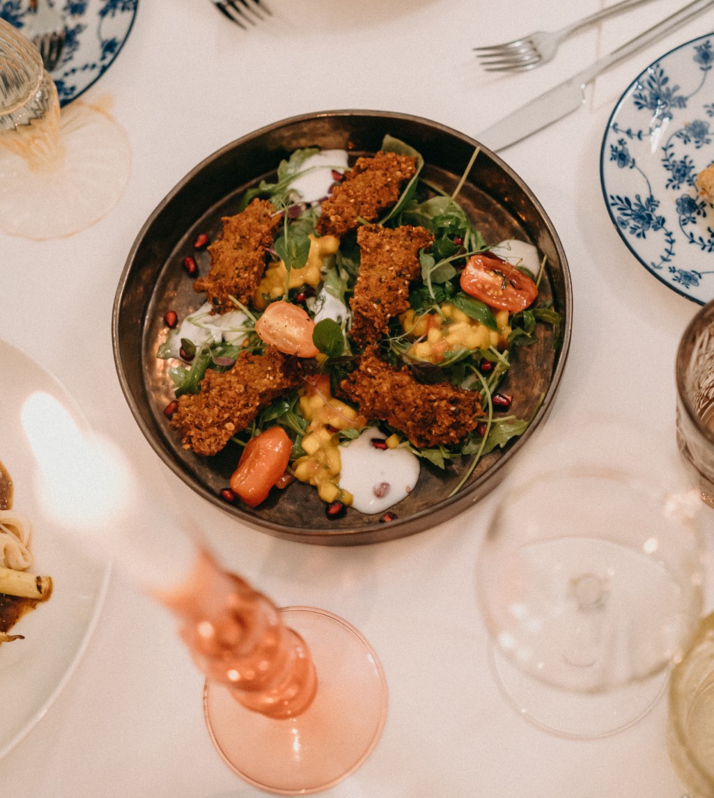 Appetitlich zubereiteter Teller mit knusprigem Hähnchen und Gemüse, garniert mit frischen Kräutern