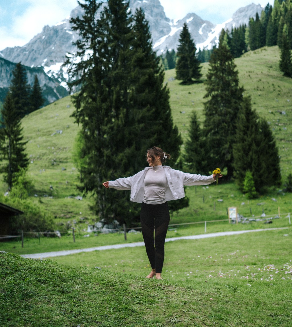 Wanderin erkundet die grünen Wiesen in Filzmoos, n, umgeben von majestätischen Bergen