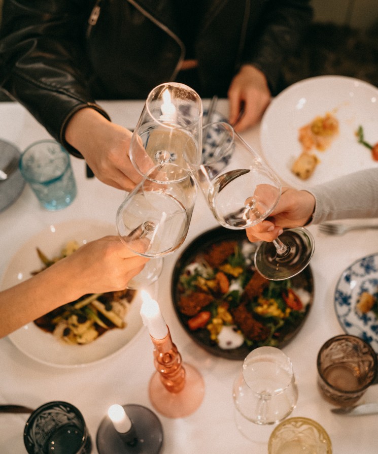 Gäste genießen ein festliches Essen mit Wein im Boutiquehotel Hubertus