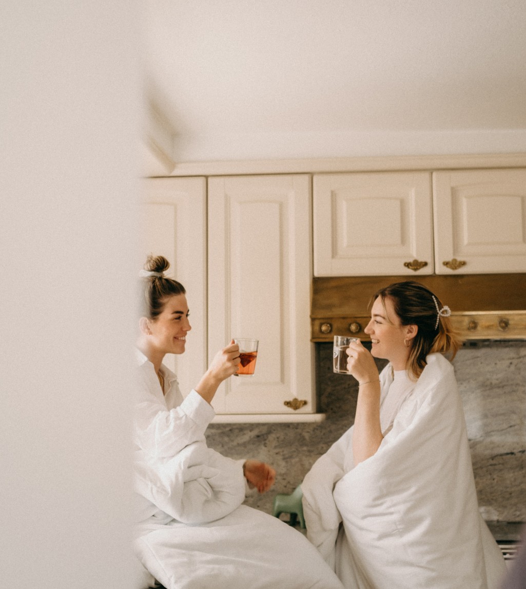 Zwei Frauen in weißen Bademänteln genießen eine entspannte Zeit zusammen im Appartement in Filzmoos